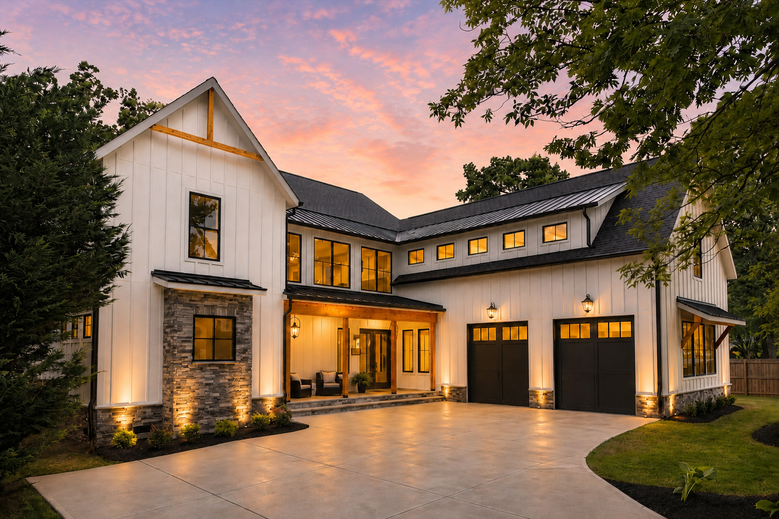 Bertonley — white board-and-batten courtyard elevation with stone accents and dark garage doors at sunset